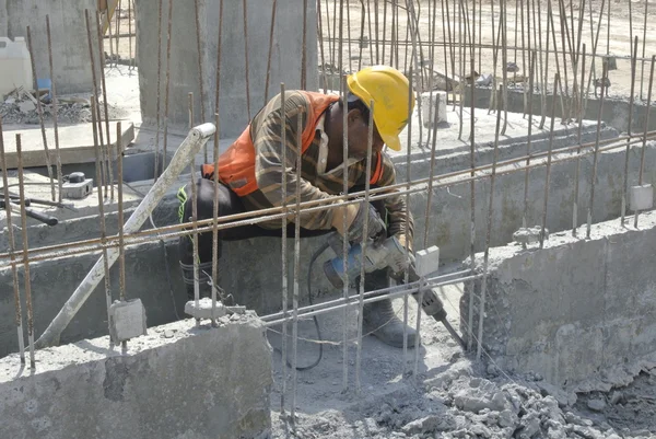 Um trabalhador de construção hacking feixe de concreto — Fotografia de Stock