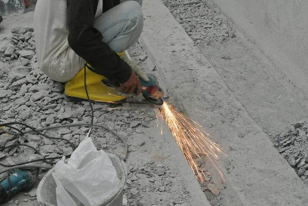 คนงานก่อสร้างบดพื้นผิวโลหะ — ภาพถ่ายสต็อก