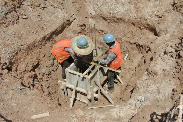 Trabajadores de la construcción instalando encofrado de casquillo —  Fotos de Stock