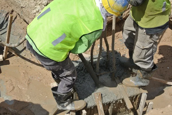 Trabalhadores da construção civil usando concreto Vibrador para compactar o concreto — Fotografia de Stock