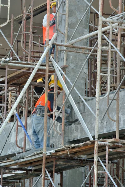 Grupo de trabajadores de la construcción que enyesan la pared del edificio —  Fotos de Stock