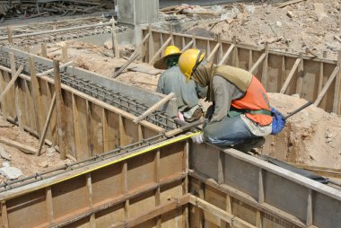 Two Construction Workers Installing Ground Beam Formwork clipart