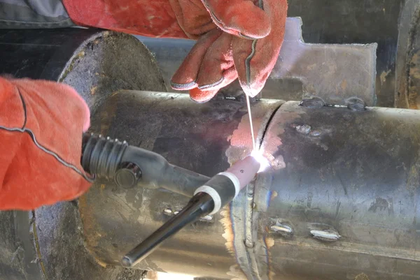 A welder welding a pipe — Stock Photo, Image