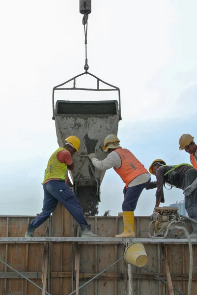 A group of construction workers pouring concrete into formwork — Stock Photo, Image