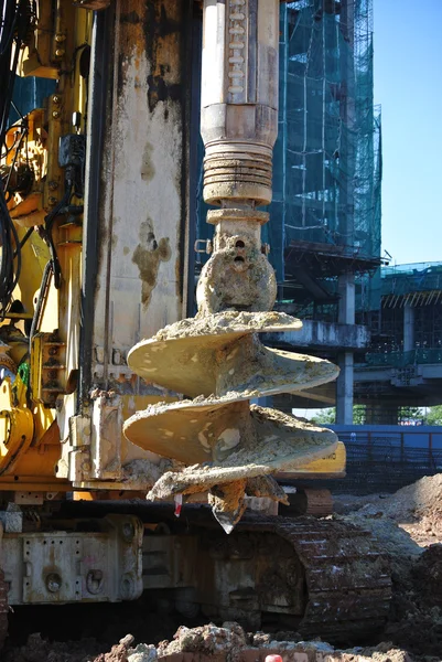建設現場で杭リグ オージェを退屈させる ロイヤリティフリーのストック写真