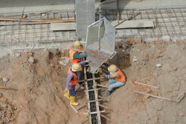 Group of construction workers casting for ground beam