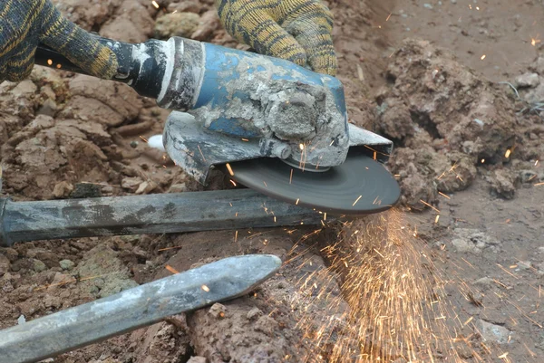Trabalhador da construção civil usando moedor de construção para afiar o aço no local de construção — Fotografia de Stock