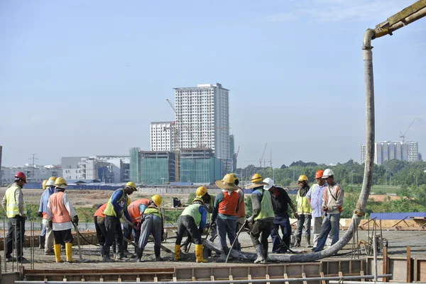 Travailleurs de la construction utilisant le tuyau de béton de la pompe à béton — Photo