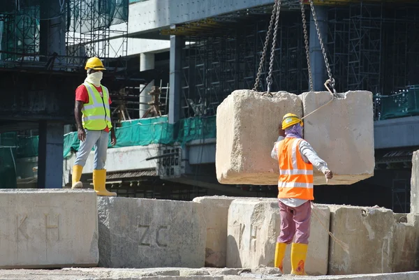 Trabalhadores da construção içando bloco de teste de carga no canteiro de obras — Fotografia de Stock