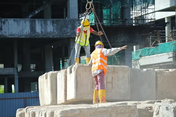 Werknemers in de bouw hijsen van lading testen blok op de bouwplaats — Stockfoto