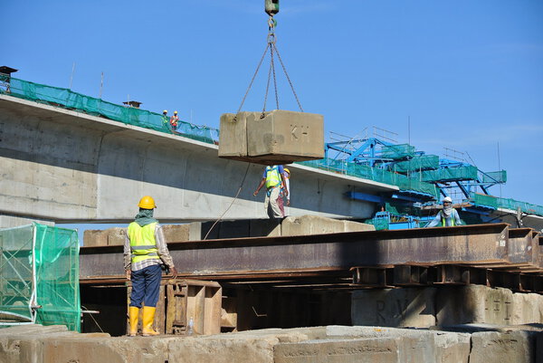 Строители штабелируют блок испытаний нагрузки на строительной площадке
