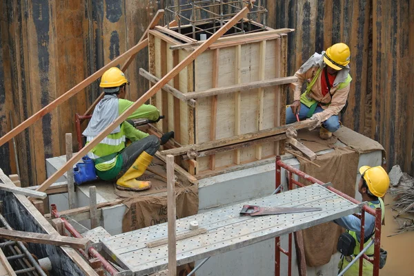 Trabajadores de la construcción instalando tapón de pila y encofrado de muñón — Foto de Stock