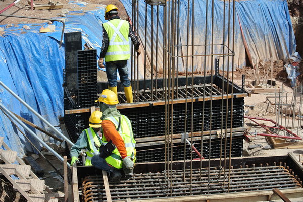 Construction workers installing pile cap and stump formwork