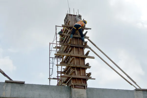 Grupo de trabajadores de la construcción que fabrican encofrados de columna —  Fotos de Stock