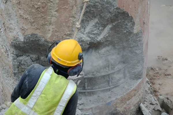 Trabajadores de la construcción que utilizan hacker móvil de hormigón en el sitio de construcción — Foto de Stock