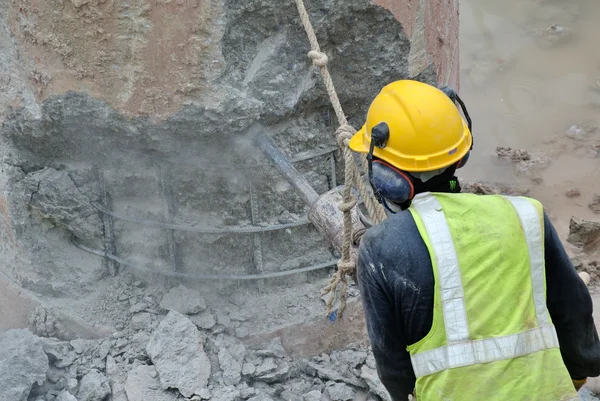 Trabajadores de la construcción que utilizan hacker móvil de hormigón en el sitio de construcción — Foto de Stock