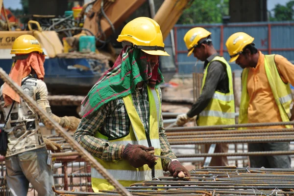 Groupe de travailleurs de la construction fabriquant des barres d'armature en acier de chapeau de pieu — Photo