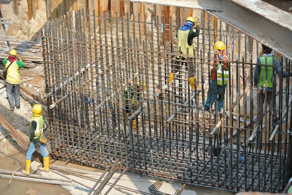 Grupo de trabajadores de la construcción que fabrican la barra de refuerzo de acero de la tapa de pila — Foto de Stock