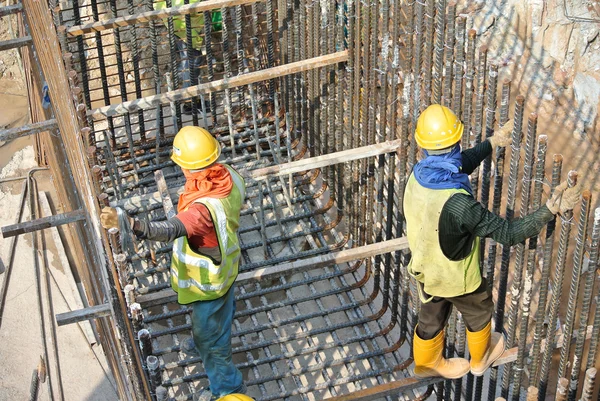 Grupo de trabajadores de la construcción que fabrican la barra de refuerzo de acero de la tapa de pila — Foto de Stock