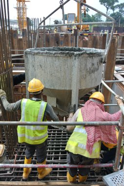 Beton yığını kap kalıp dökme inşaat işçilerin bir grup