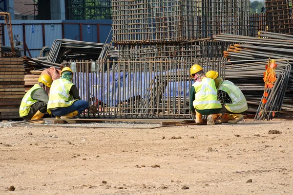 Trabajadores de la construcción que fabrican la barra de refuerzo de la tapa de pila en el sitio de construcción — Foto de Stock