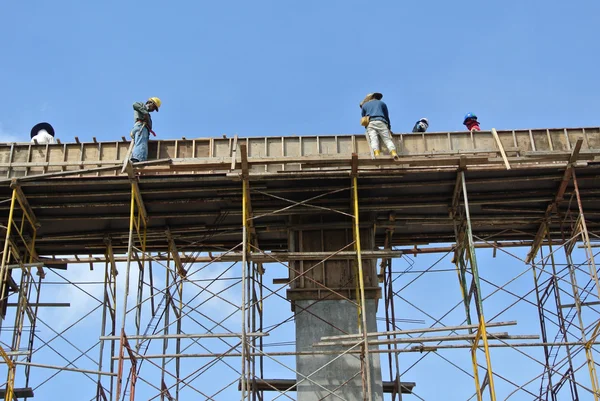 Grupo de trabajadores de la construcción que fabrican encofrados de vigas —  Fotos de Stock