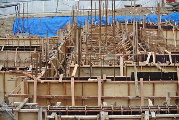 Construction workers fabricate ground beam formwork