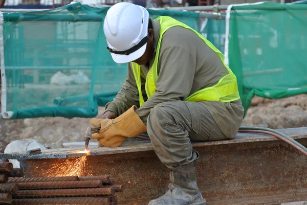İnşaat alanında kaynak makinesini kullanarak inşaat işçileri kesme metal