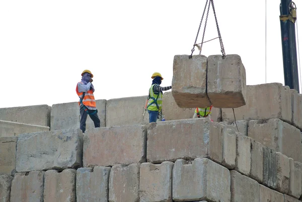 Werknemers in de bouw stapelen de behouden belasting test blok op de bouwplaats — Stockfoto