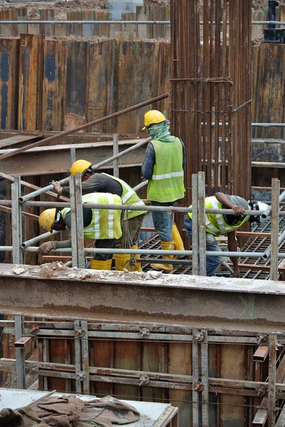 Travailleurs de la construction préparant des pieux pour le bétonnage — Photo