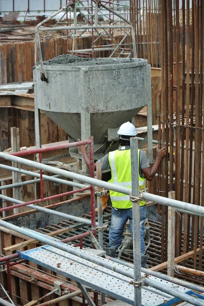 Eine Gruppe von Bauarbeitern schüttet Betonschlämme in die Pfahldeckelschalung — Stockfoto