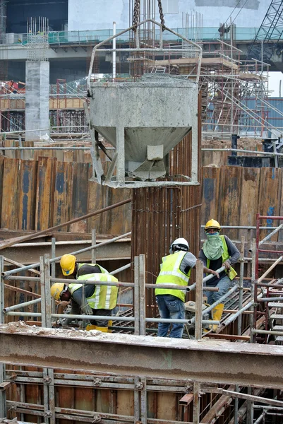 杭キャップ型枠にコンクリートのスラリーを注いで建設労働者のグループ — ストック写真