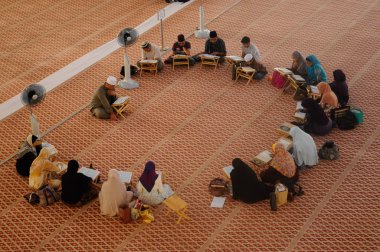 Group of people studying religion inside National Mosque of Malaysia clipart
