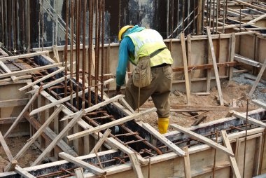 Construction workers fabricating ground beam formwork clipart