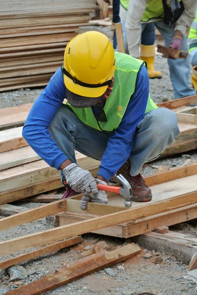 Плотник изготавливает деревянные формы на строительной площадке — стоковое фото