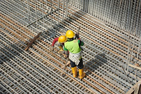 Gruppe von Bauarbeitern, die Stahlbewehrungsstangen herstellen — Stockfoto