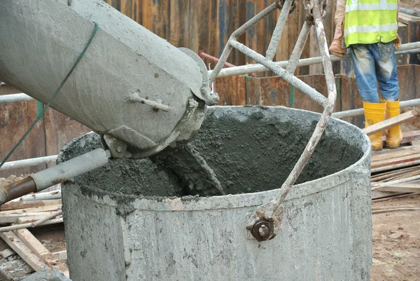 Бетонное ведро, принимающее бетон из бетонного грузовика — стоковое фото
