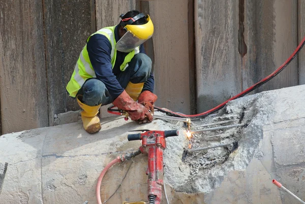Pekerja di lokasi konstruksi memotong logam menggunakan obor las — Stok Foto