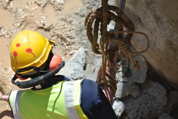 Trabajadores de la construcción que utilizan hacker móvil de hormigón en el sitio de construcción —  Fotos de Stock