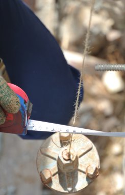 İnşaat alanında ölçüm bandı kullanarak işçi