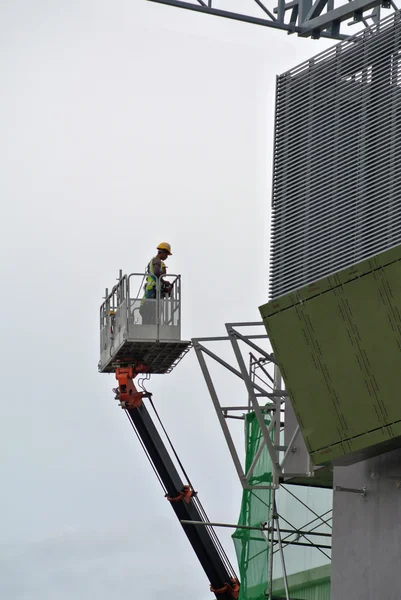 Travailleurs de la construction utilisant le panier de grue mobile — Photo