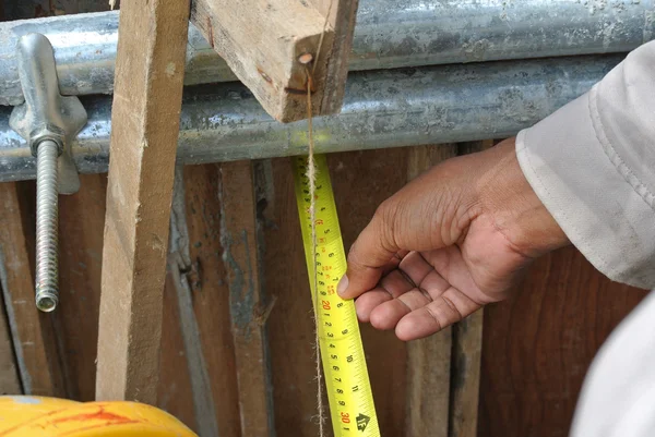 Trabalhadores que utilizam fita métrica no estaleiro de construção — Fotografia de Stock