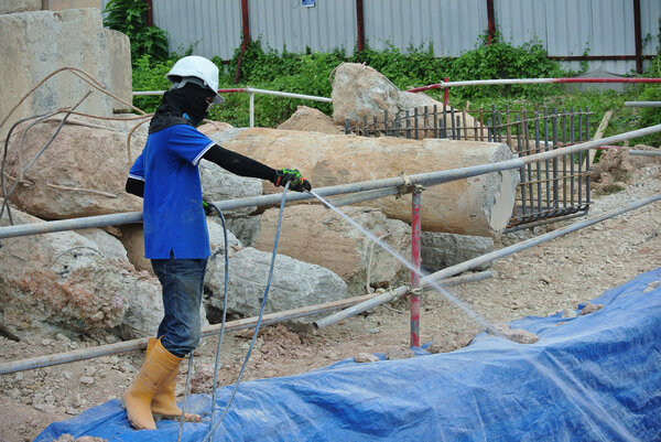 Строители распыляют антитермитовую химическую обработку
