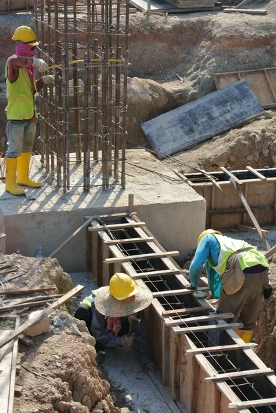 Grupo de trabalhadores da construção civil que fabricam cofragem de feixe de terra — Fotografia de Stock