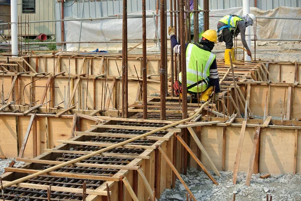 Grupo de trabajadores de la construcción que fabrican encofrados de vigas de tierra — Foto de Stock