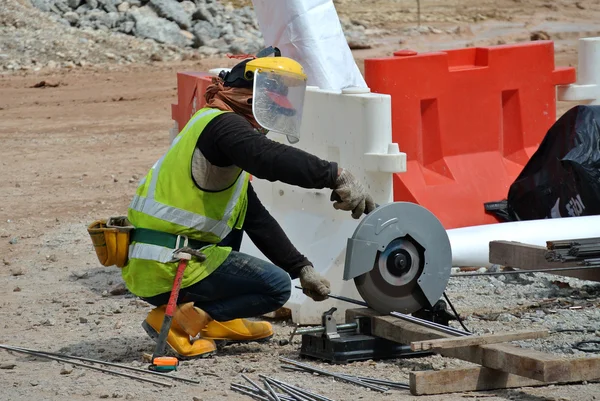 Un trabajador de la construcción que utiliza la máquina cortadora de tubos portátil de uso general — Foto de Stock