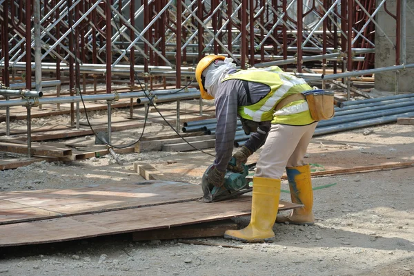 Carpenter using circular saw at the construction site — Stock Photo, Image