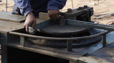 Workers using the bar bending machine