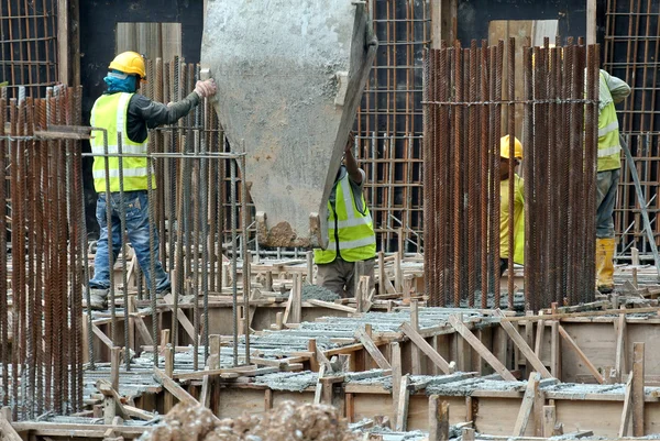 Skupina stavební dělníci betonování desky & paprsek na staveništi — Stock fotografie