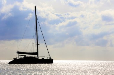 Yelken tekne siluet günbatımında bir denizde